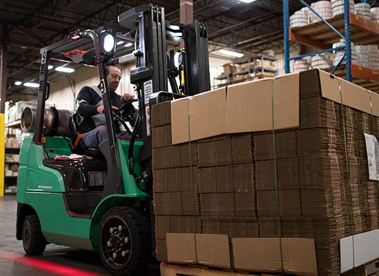 Operator Lifting up Merchandise on a Pallet with a Mitsubishi Forklift